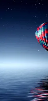 Hot air balloon floating over a starry ocean at night.