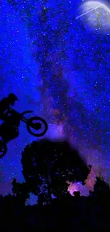 Silhouette of biker jumping under a vivid starry night sky.