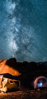 Camping tents under a starry night sky with Milky Way view.