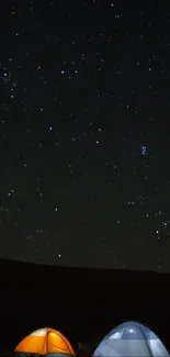 Camping tents illuminated under a starry night sky.