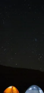 Starry night sky with two glowing camping tents under the stars.