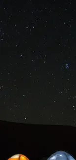 Camping under a starry night sky with two tents in view.