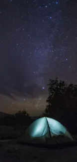 Camp lit under a starry night sky with glowing tent.