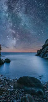 Starry night sky over a serene coastal scene with rocky shoreline.