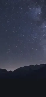 Starry night sky above mountain silhouettes.