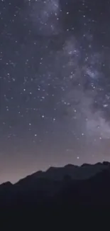 Starry night sky over mountains, featuring the Milky Way.