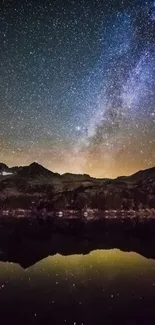 A stunning starry night sky over mountains with galaxy view reflected in water.