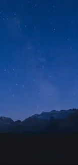 Starry night sky above mountain silhouette in tranquil scene.