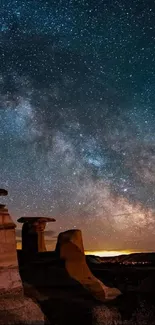 Starry sky over Alberta hoodoos in stunning night landscape.