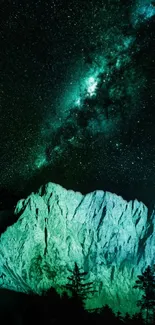 Starry sky over mountains with green glow.