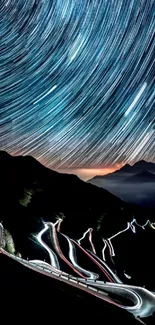 Star trails over winding mountain road at night.