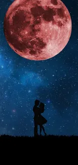 Silhouetted couple under red moon in starry night sky wallpaper.