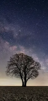 Lone tree under a starry night sky, perfect for nature-themed mobile wallpaper.