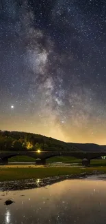 Starry night sky over a bridge with reflections in calm water.