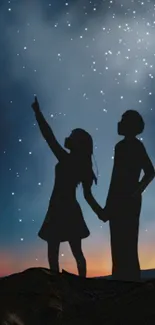 Silhouette of couple under a starry night sky.