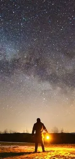 Person with lantern under starry sky showcasing Milky Way.