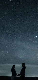 Silhouetted couple under a starry night sky.