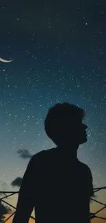 Silhouette against a starry night sky with crescent moon wallpaper.