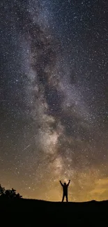 Silhouette under the starry Milky Way night sky, showcasing cosmic beauty.