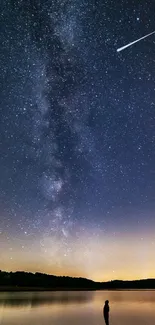 Starry night sky with a shooting star over a calm lake landscape.