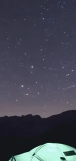 Glowing tent under a starry night sky with mountains.