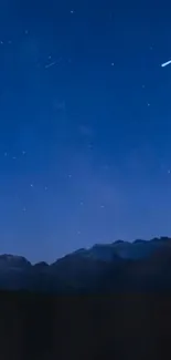 Starry night sky with mountains in silhouette.