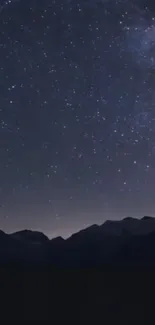 Starry night sky with mountain silhouette, perfect for mobile wallpaper.