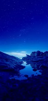 Mobile wallpaper of a starry night sky over rocky terrain in deep blue hues.