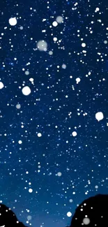 Starry night sky with snowflakes falling on a deep blue background.