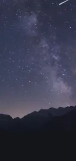 A serene starry night sky over mountains with a shooting star.