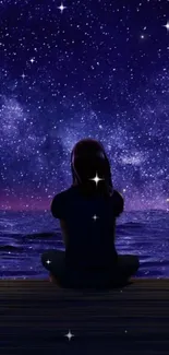 Person gazes at starry night sky over ocean.