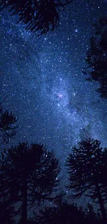 Silhouetted trees under a starry night sky with galaxies.