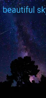 Silhouette of a tree against a starry night sky with galaxies.