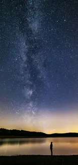 Silhouette by a lake under a star-filled night sky.