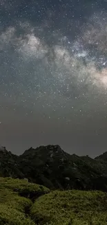 Star-filled night sky over rolling green hills.