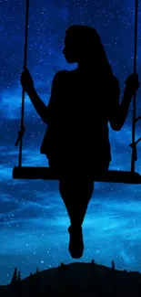 Silhouette on a swing beneath a starry night sky.