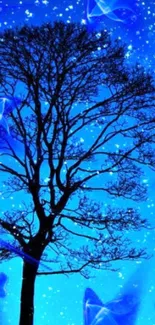 A silhouetted tree against a vibrant, starry blue night sky.