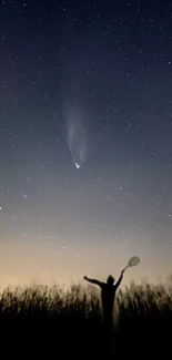 Silhouette under a starry sky with a comet visible.