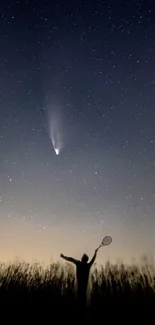 Silhouette under a starry night sky with visible comet.