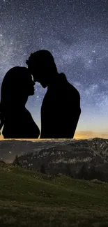 Silhouette of a couple against a starry night sky with scenic mountains.