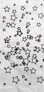 Minimalist black stars on crumpled paper wallpaper.