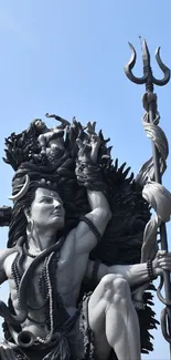 Monumental statue set against a bright blue sky background.