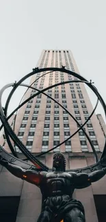 Bronze statue with skyscraper background.