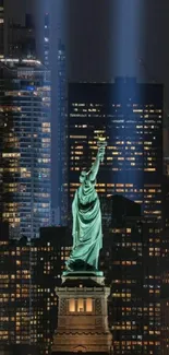 Statue of Liberty with NYC skyline illuminated at night.