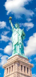 Statue of Liberty with blue sky background, viewed from a low angle.