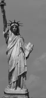 Black and white image of the Statue of Liberty with clouds in the background.