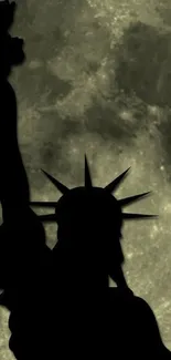 Silhouette of Statue of Liberty against a full moon.