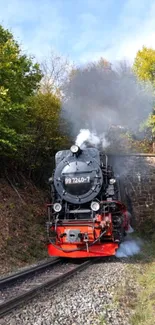 Steam train exiting a tunnel surrounded by lush green trees.