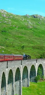 Steam train crossing a scenic viaduct with lush green hills.