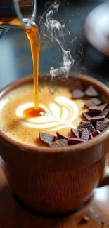 Steam rises from coffee topped with chocolate shavings in a wooden cup.